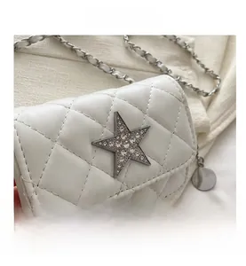 Close-up of quilted mini bag with a sparkling star buckle and woven leather chain