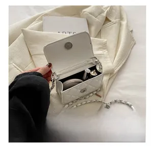 Internal view of the white quilted mini crossbody bag showing storage for lipstick and powder