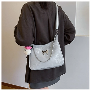 Silver grey textured crossbody bag featuring metallic butterfly detail and plush charm