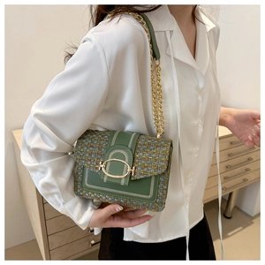 Detail of green leather small square bag with colorful tweed flap and gold chain strap