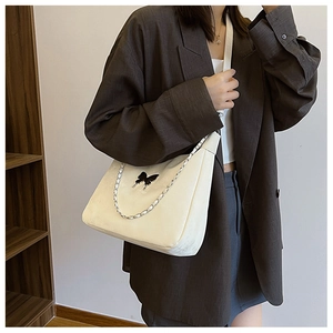 Minimalist white PU leather shoulder bag with black butterfly charm and chain strap