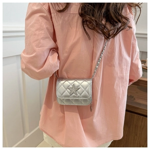 Detail of silver quilted mini crossbody bag with star emblem and metal chain strap