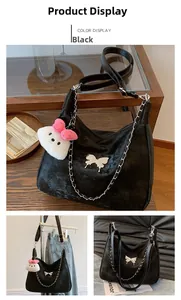 Detail of black velvet shoulder bag with silver butterfly buckle and cat plush pendant