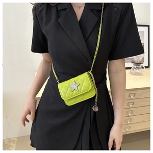 Detail of neon green quilted mini bag with silver star buckle and metal chain strap