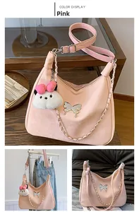 Detailed view of a pink suede hobo bag with butterfly hardware and plush charm
