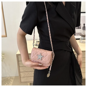 Pink quilted mini crossbody bag with crystal star and silver chain strap shown on model