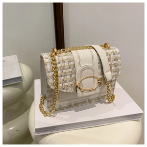 Close-up of quilted tweed flap bag featuring elegant gold hardware and chain strap