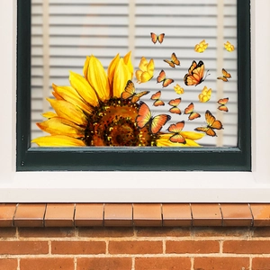 Detail view of sunflower and butterfly window stickers on a glass pane with natural light