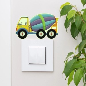 Detailopname van een lichtschakelaarsticker met betonmixer op een witte muur met plant