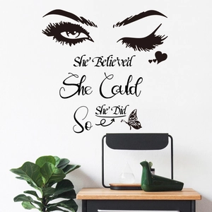 Détail du sticker mural noir avec cils papillon et texte She Believed She Could inspirant