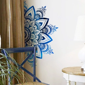 Détail d'un autocollant mural mandala bleu sur mur blanc à côté d'une chaise bleue