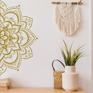 Detail of golden mandala wall sticker with geometric heart patterns in boho living room