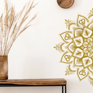 Detail of a large gold mandala wall decal with floral geometric patterns in a cozy room