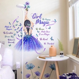 Détail du sticker mural avec fleurs, papillons et citation Girl Magic dans une chambre