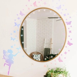 Luminous fairy butterfly and star wall decals decorating a round gold-framed mirror on wall