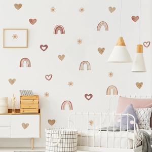 Détail de stickers muraux arc-en-ciel et cœurs dans une chambre d'enfant de style nordique