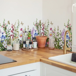 Floral wall decal with colorful wildflowers and butterflies on a white kitchen backsplash