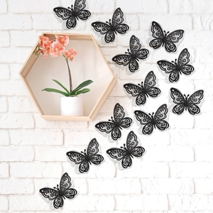 Detalle macro de mariposas 3D negras caladas sobre una pared de ladrillos blancos