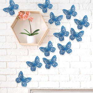 Detalle de 12 mariposas 3D azules caladas con purpurina para decoración de pared blanca