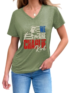 Close-up of V-neck T-shirt with Charlie Kirk portrait and US flag print on green fabric