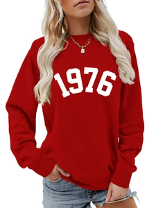 Detail of red crewneck sweatshirt with white 1976 vintage print and golden necklace