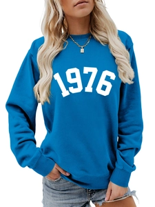 Close-up of blue crewneck sweatshirt featuring white 1976 print and ribbed cuffs