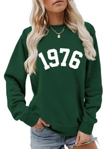 Close-up of the vintage 1976 white print on this dark green crewneck sweatshirt