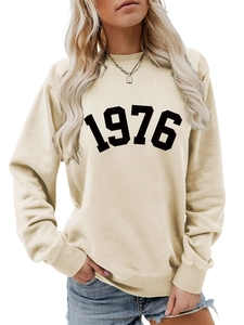 Close-up of ribbed neckline and vintage 1976 black print on cream women sweatshirt