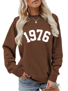 Detail of white 1976 digital print on dark brown crewneck sweatshirt with ribbed cuffs
