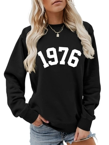 Detail of black crewneck sweatshirt featuring white 1976 printed numerals and ribbed cuffs