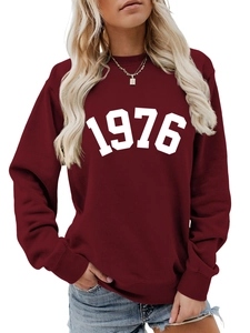 Close-up of the white 1976 graphic print on a burgundy crewneck sweatshirt for women
