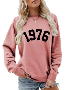 Detail showing the 1976 printed pattern and ribbed cuff on the pink crewneck sweatshirt