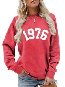 Close-up of the ribbed crewneck and bold 1976 white print on a red cotton sweatshirt