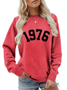 Detail of red crewneck sweatshirt featuring a black artistic 1976 printed graphic design