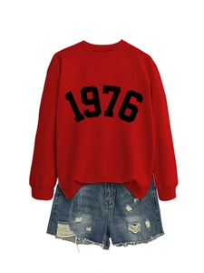 Detail of red crewneck sweatshirt with black 1976 print and distressed denim shorts