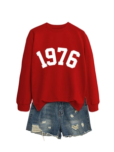 Detail view of red crewneck sweatshirt with 1976 print and distressed denim shorts
