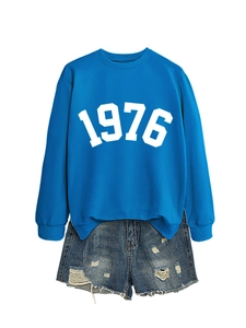 Detail of blue 1976 sweatshirt paired with distressed ripped denim shorts on white background