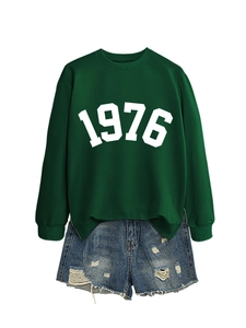 Detail of dark green sweatshirt with 1976 print and distressed denim shorts