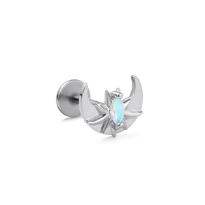 Close-up of stainless steel labret stud with crescent moon and opal stone detail