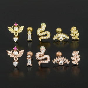 Surgical steel cartilage studs featuring moon, wing, snake and evil eye designs in gold finish