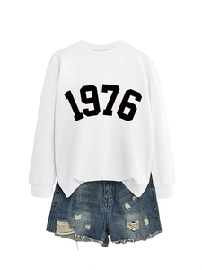 Detail of white 1976 printed sweatshirt paired with distressed denim shorts
