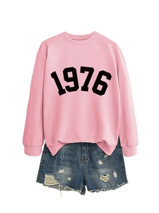 Detail of pink sweatshirt with 1976 print and distressed denim shorts set in studio flat lay