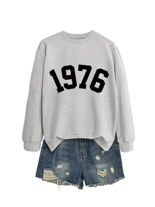 Close-up of grey 1976 sweatshirt fabric and distressed blue denim shorts texture