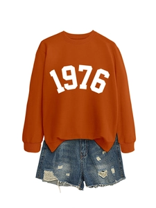 Close-up of 1976 printed orange sweatshirt paired with distressed denim shorts