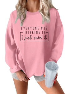 Detalle de sudadera rosa con estampado de eslogan negro en el pecho para mujer