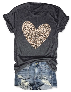 Flat lay of gray T-shirt with leopard heart print and ripped denim shorts on white background