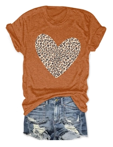 Flat lay of orange t-shirt with leopard print heart and distressed denim shorts