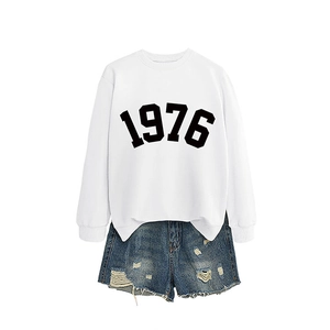 Minimalist white sweatshirt with 1976 print paired with distressed denim shorts