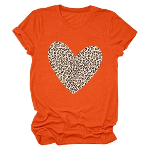 Detail of a bright orange T-shirt featuring a large leopard print heart and rolled sleeves