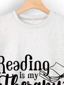 Detailed texture of light gray cotton sweatshirt with Reading is my Therapy print
